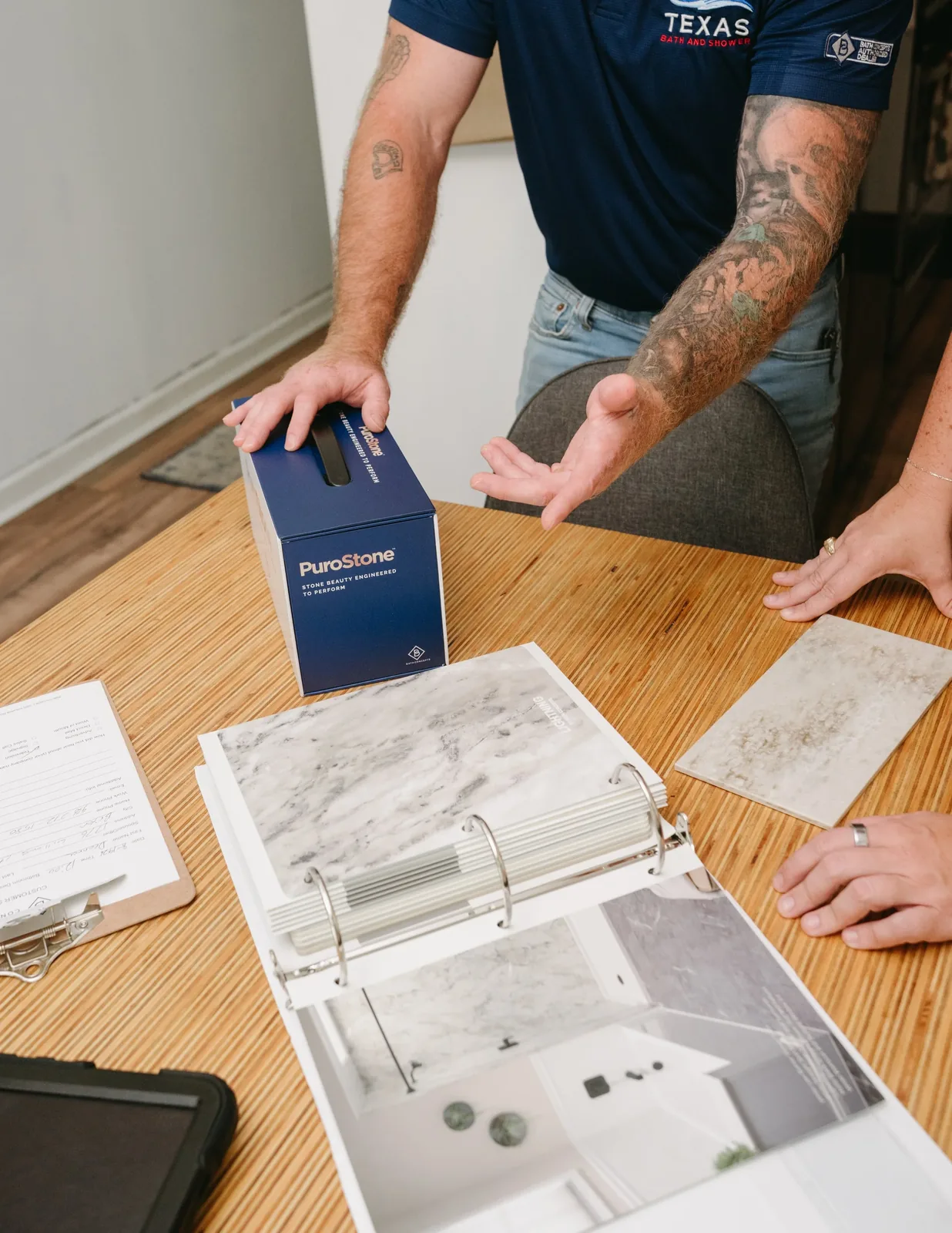 Texas Bath and Shower team member reviewing bathroom material selections with a homeowner